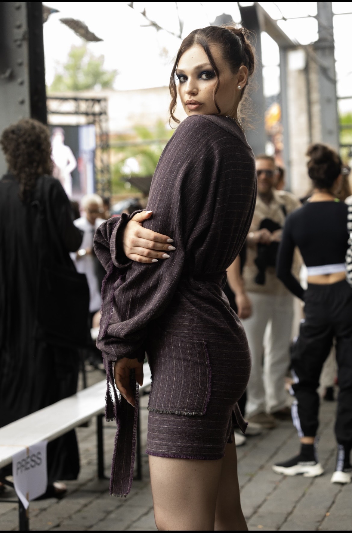 Adeline Frickel backstage in a plum pinstripe knit ensemble