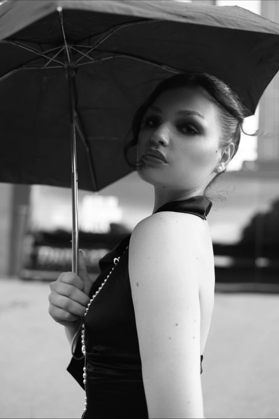 Black and white portrait of Adeline Frickel under a black umbrella